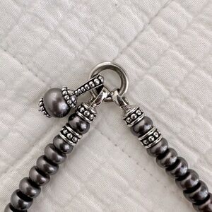 Cultured pearl and silver necklace with charm.